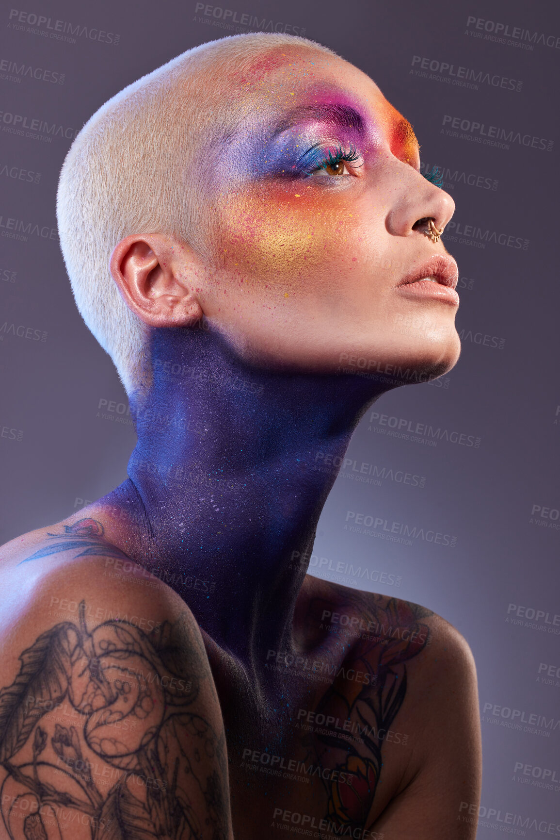 Buy stock photo Studio shot of a young woman posing with multi-coloured paint on her face