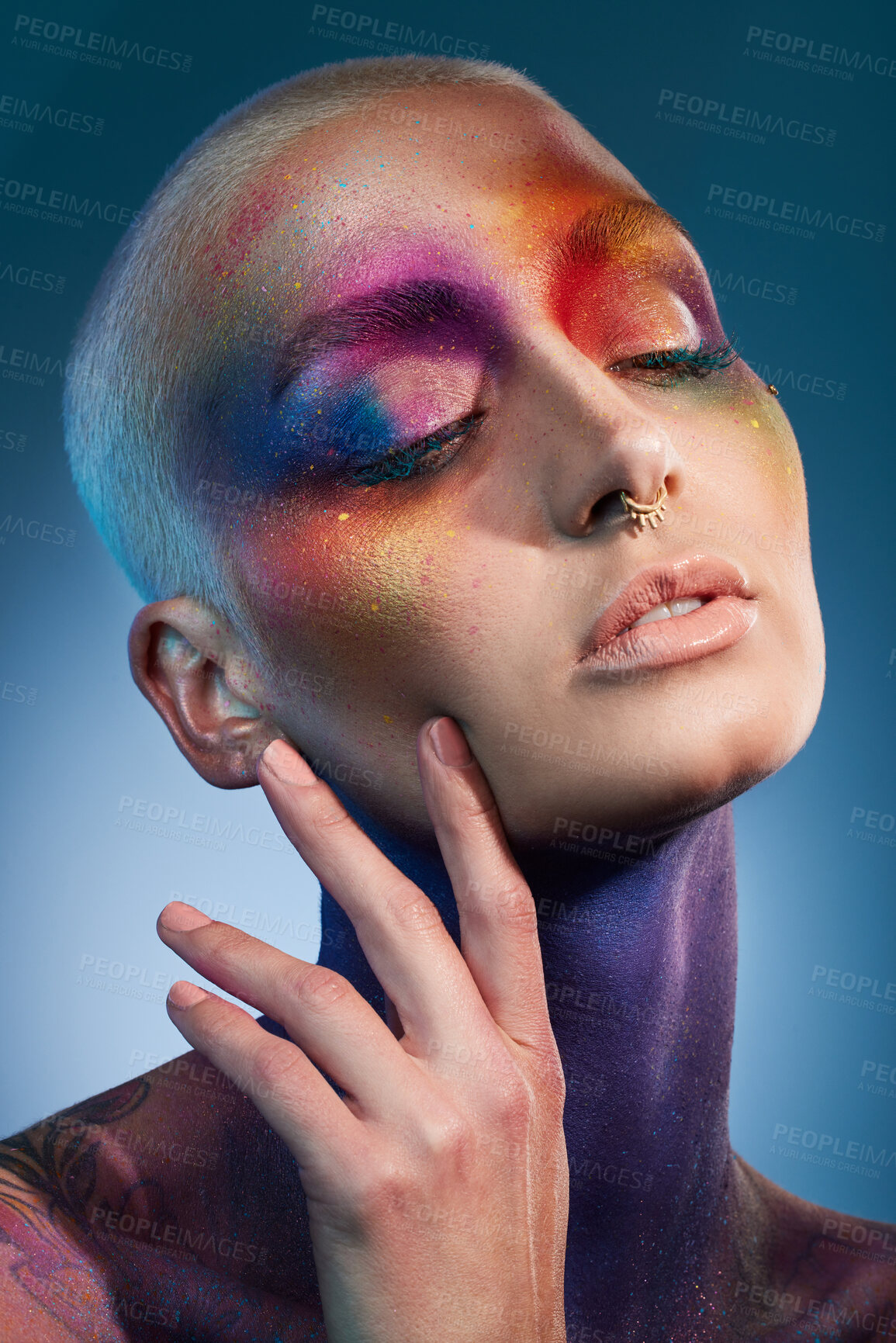 Buy stock photo Studio shot of a young woman posing with multi-coloured paint on her face