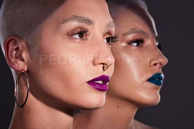 Buy stock photo Studio shot of two beautiful young woman posing against a dark background