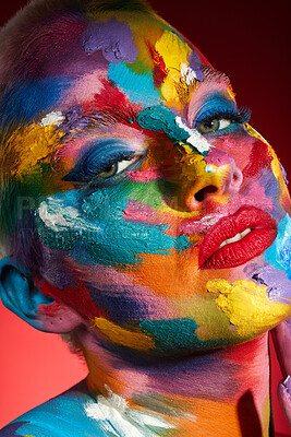 Buy stock photo Studio shot of a young woman posing with multi-coloured paint on her face