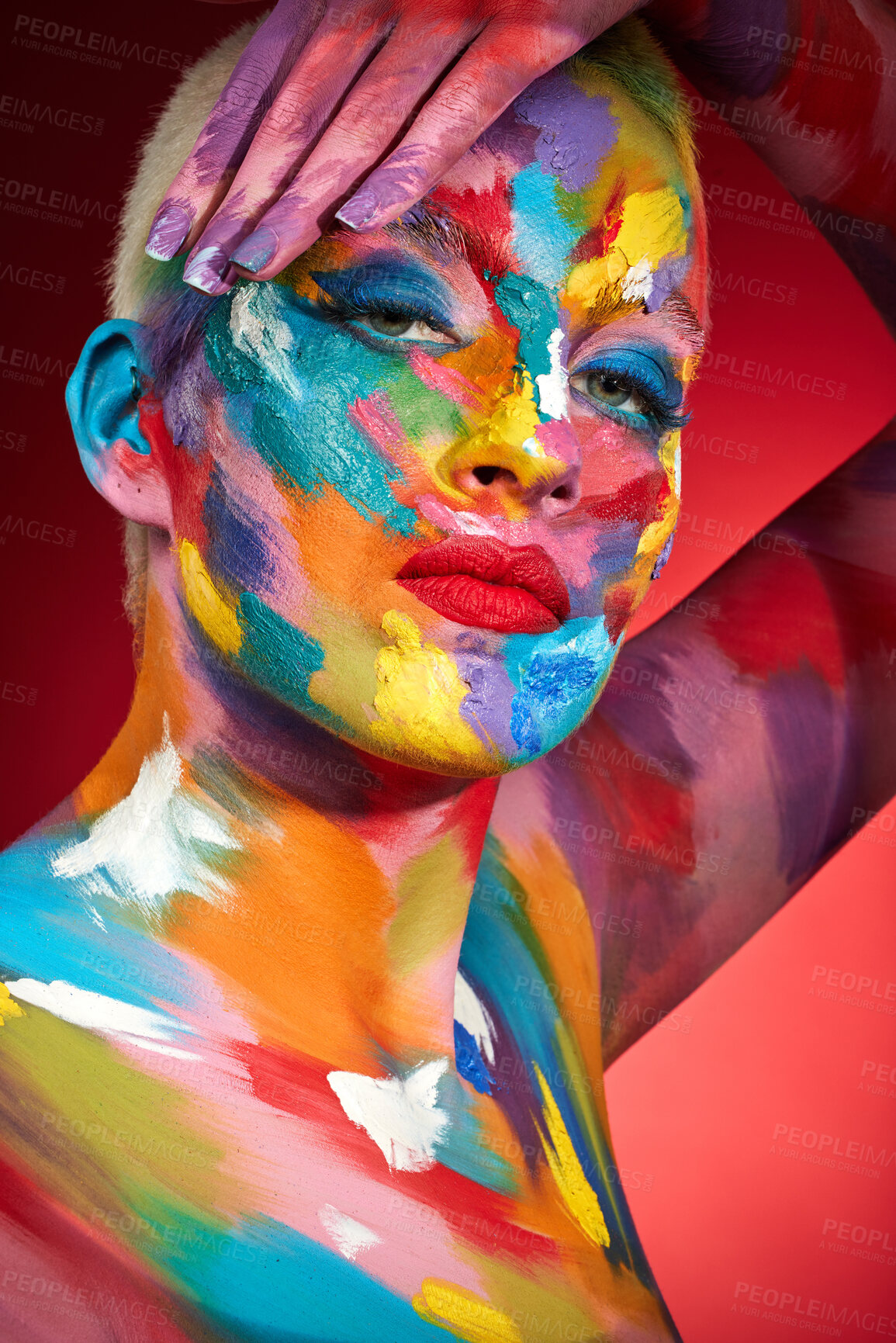 Buy stock photo Studio shot of a young woman posing with multi-coloured paint on her face