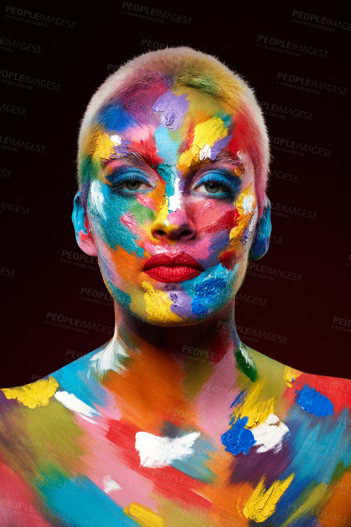 Buy stock photo Studio shot of a young woman posing with multi-coloured paint on her face