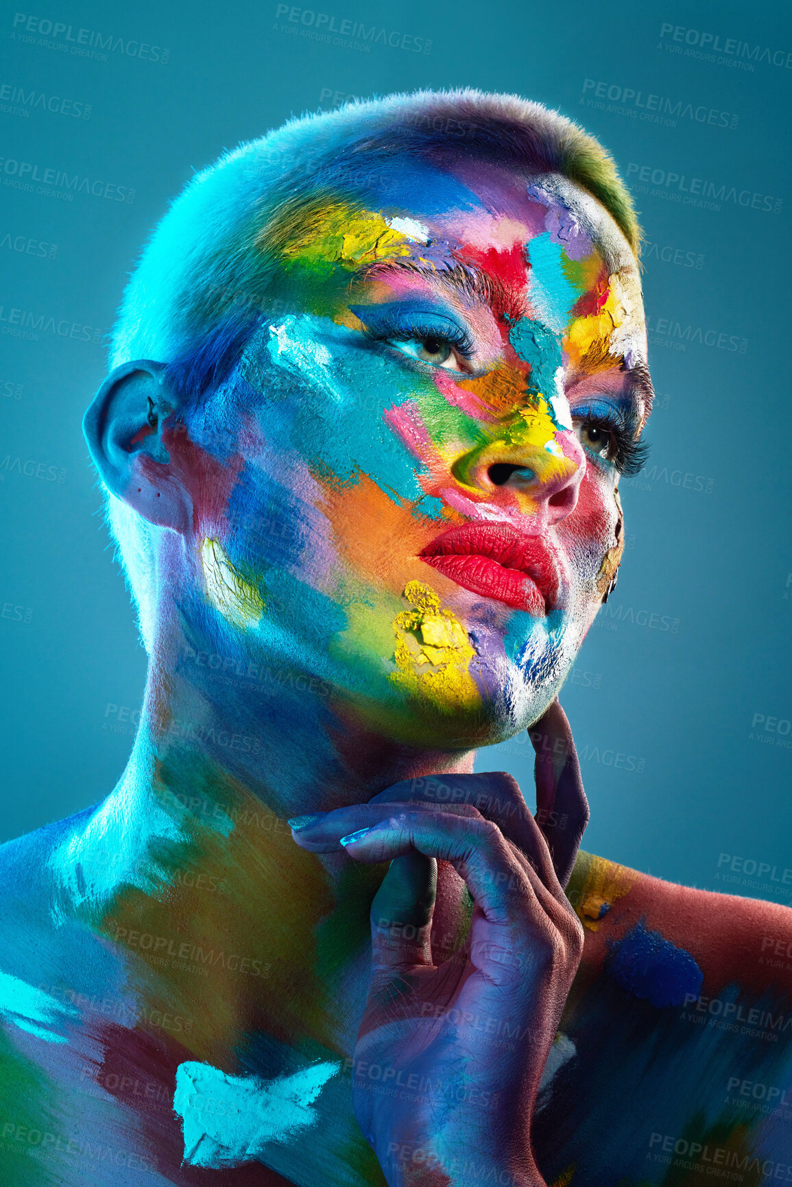 Buy stock photo Studio shot of a young woman posing with multi-coloured paint on her face