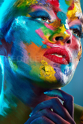 Buy stock photo Studio shot of a young woman posing with multi-coloured paint on her face