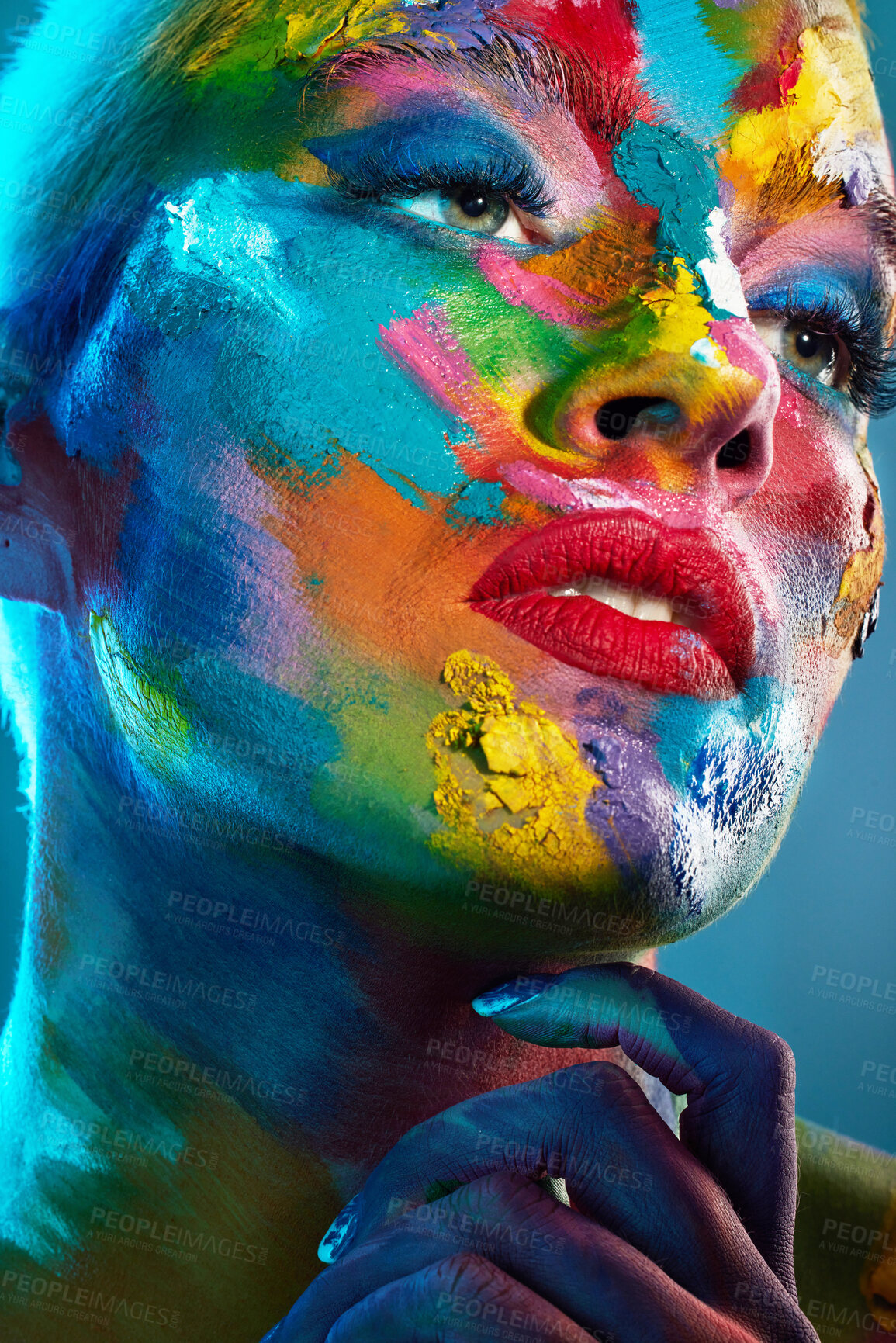 Buy stock photo Studio shot of a young woman posing with multi-coloured paint on her face