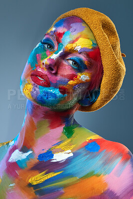 Buy stock photo Studio shot of a young woman posing with multi-coloured paint on her face and a french hat on her head