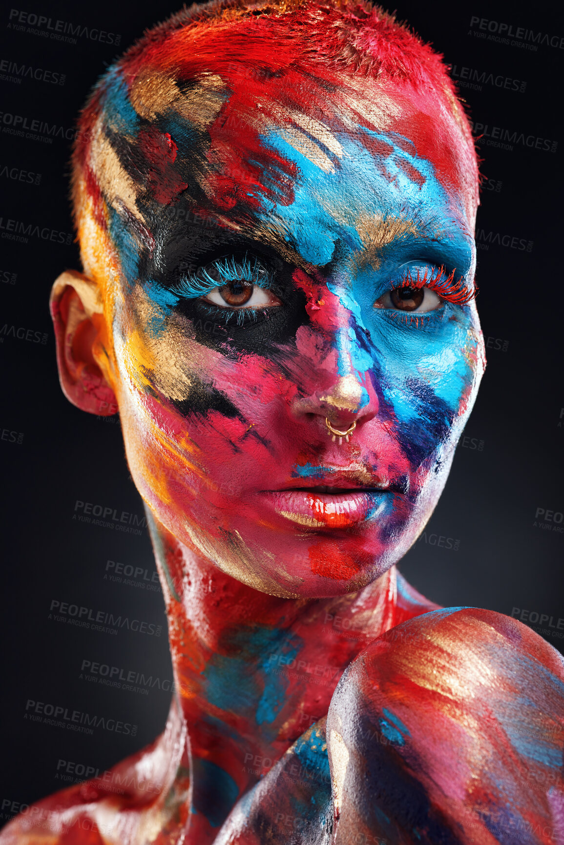 Buy stock photo Shot of an attractive young woman posing alone in the studio with paint on her face