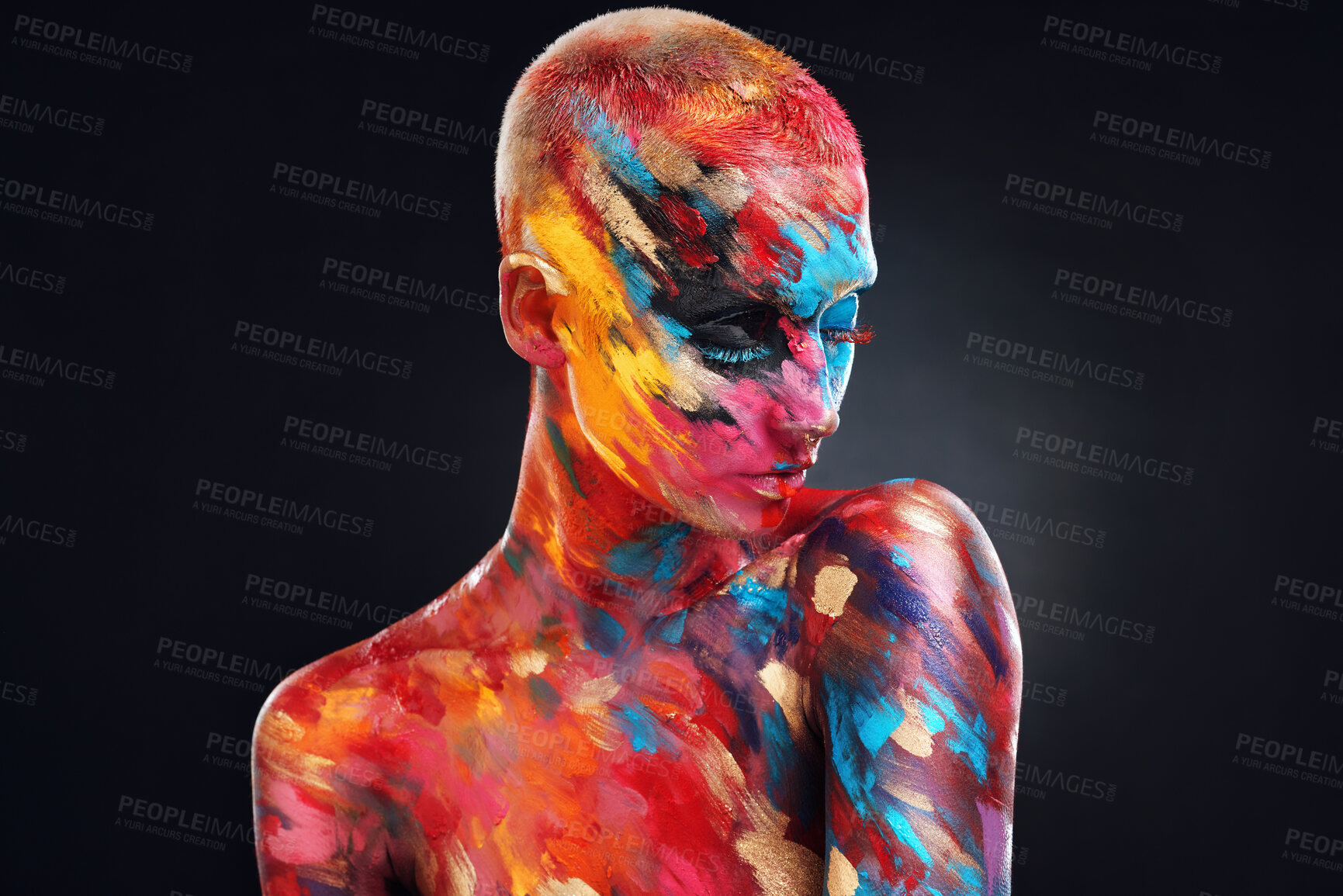 Buy stock photo Shot of an attractive young woman posing alone in the studio with paint on her face and body
