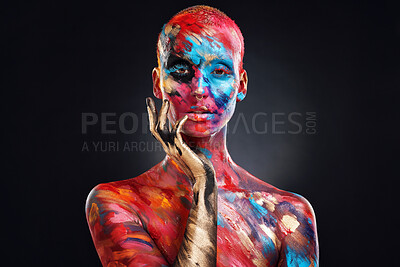 Buy stock photo Shot of an attractive young woman posing alone in the studio with paint on her face and body