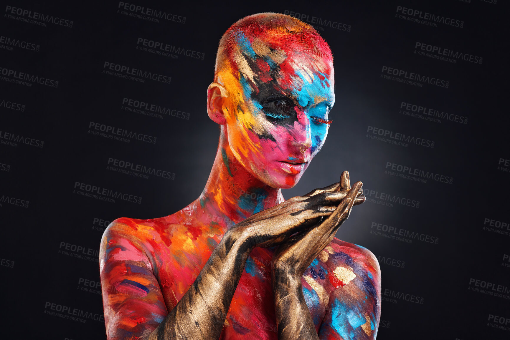 Buy stock photo Shot of an attractive young woman posing alone in the studio with paint on her face and body