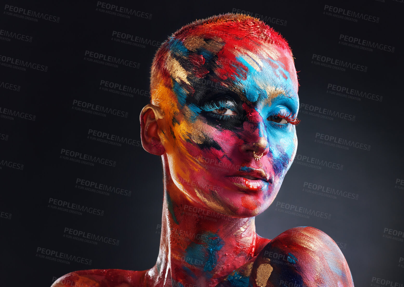 Buy stock photo Shot of an attractive young woman posing alone in the studio with paint on her face