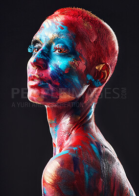 Buy stock photo Shot of an attractive young woman posing alone in the studio with paint on her face and body