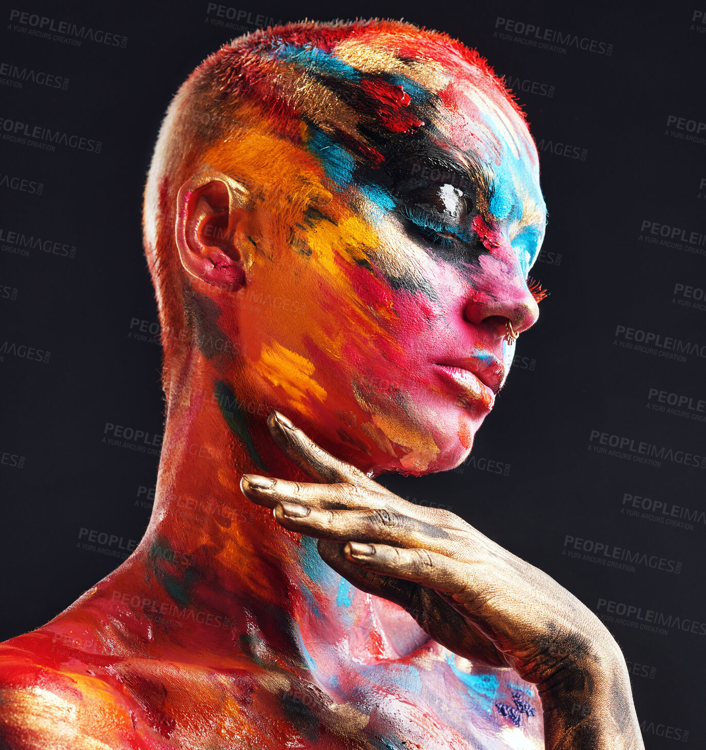 Buy stock photo Shot of an attractive young woman posing alone in the studio with paint on her face and body