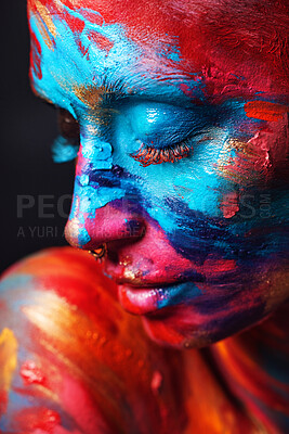 Buy stock photo Shot of an attractive young woman posing alone in the studio with paint on her face