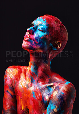 Buy stock photo Shot of an attractive young woman posing alone in the studio with paint on her face and body