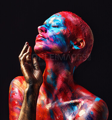 Buy stock photo Shot of an attractive young woman posing alone in the studio with paint on her face and body