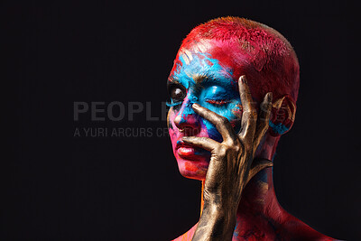 Buy stock photo Shot of an attractive young woman posing alone in the studio with paint on her face