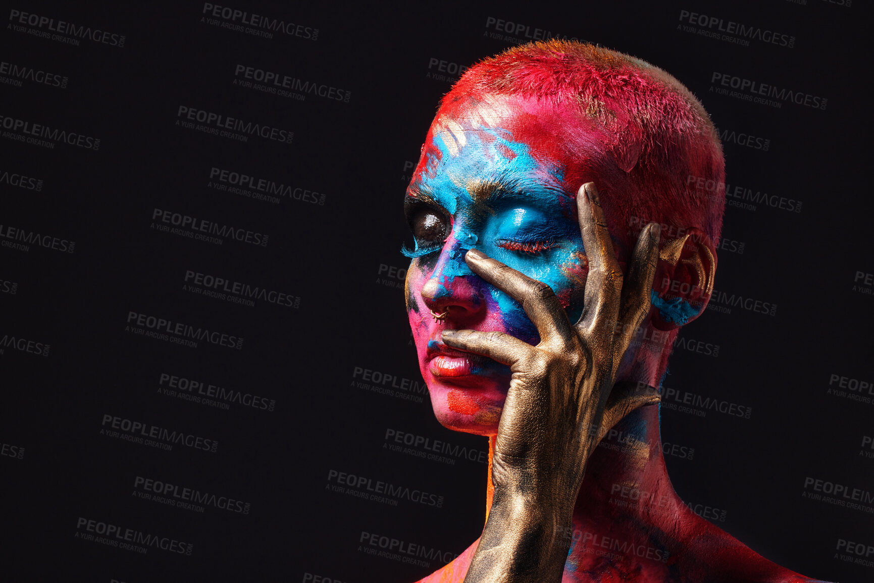 Buy stock photo Shot of an attractive young woman posing alone in the studio with paint on her face