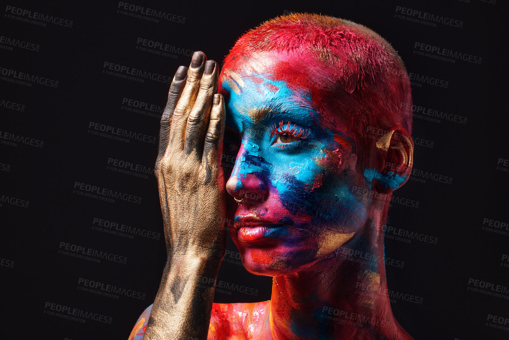 Buy stock photo Shot of an attractive young woman posing alone in the studio with paint on her face