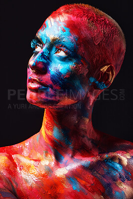 Buy stock photo Shot of an attractive young woman posing alone in the studio with paint on her face and body