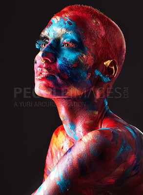 Buy stock photo Shot of an attractive young woman posing alone in the studio with paint on her face and body