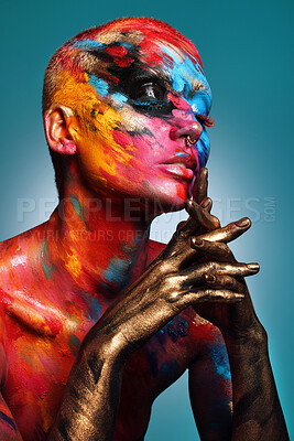 Buy stock photo Shot of an attractive young woman posing alone in the studio with paint on her face and body