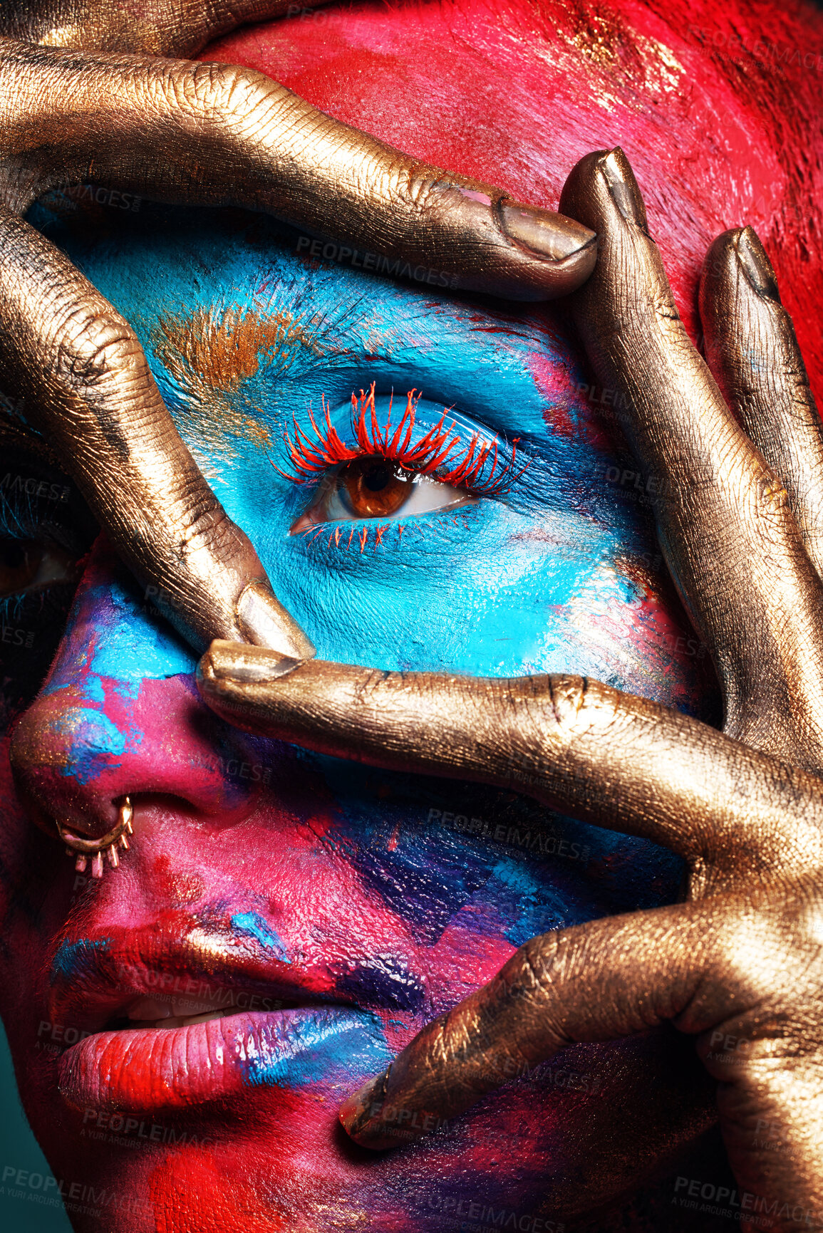 Buy stock photo Shot of an attractive young woman posing alone in the studio with paint on her face