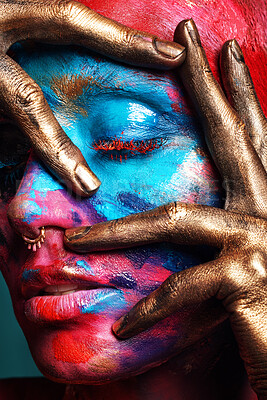 Buy stock photo Shot of an attractive young woman posing alone in the studio with paint on her face