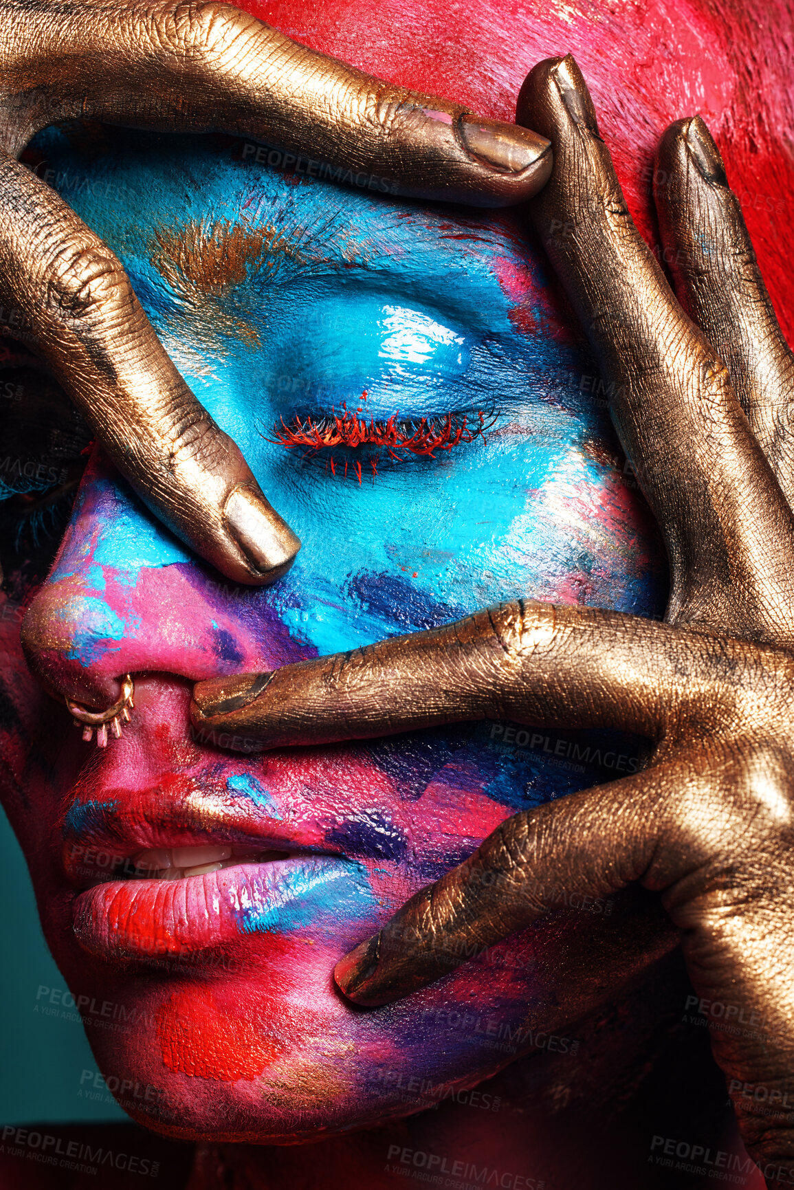 Buy stock photo Shot of an attractive young woman posing alone in the studio with paint on her face