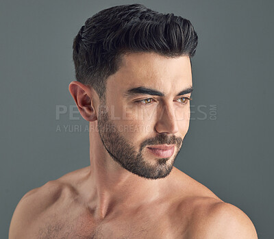 Buy stock photo Shot of a handsome young man posing against a grey background