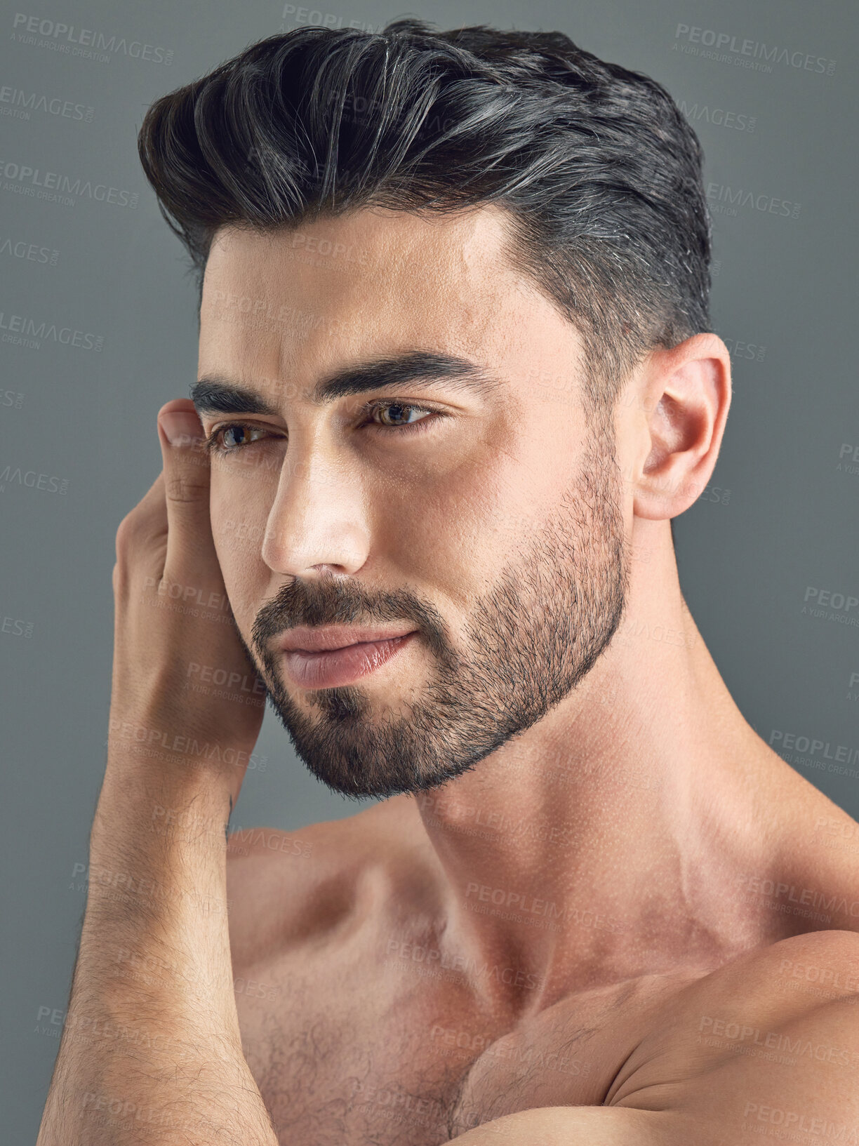 Buy stock photo Shot of a handsome young man posing against a grey background