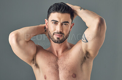 Buy stock photo Shot of a handsome young man posing against a grey background