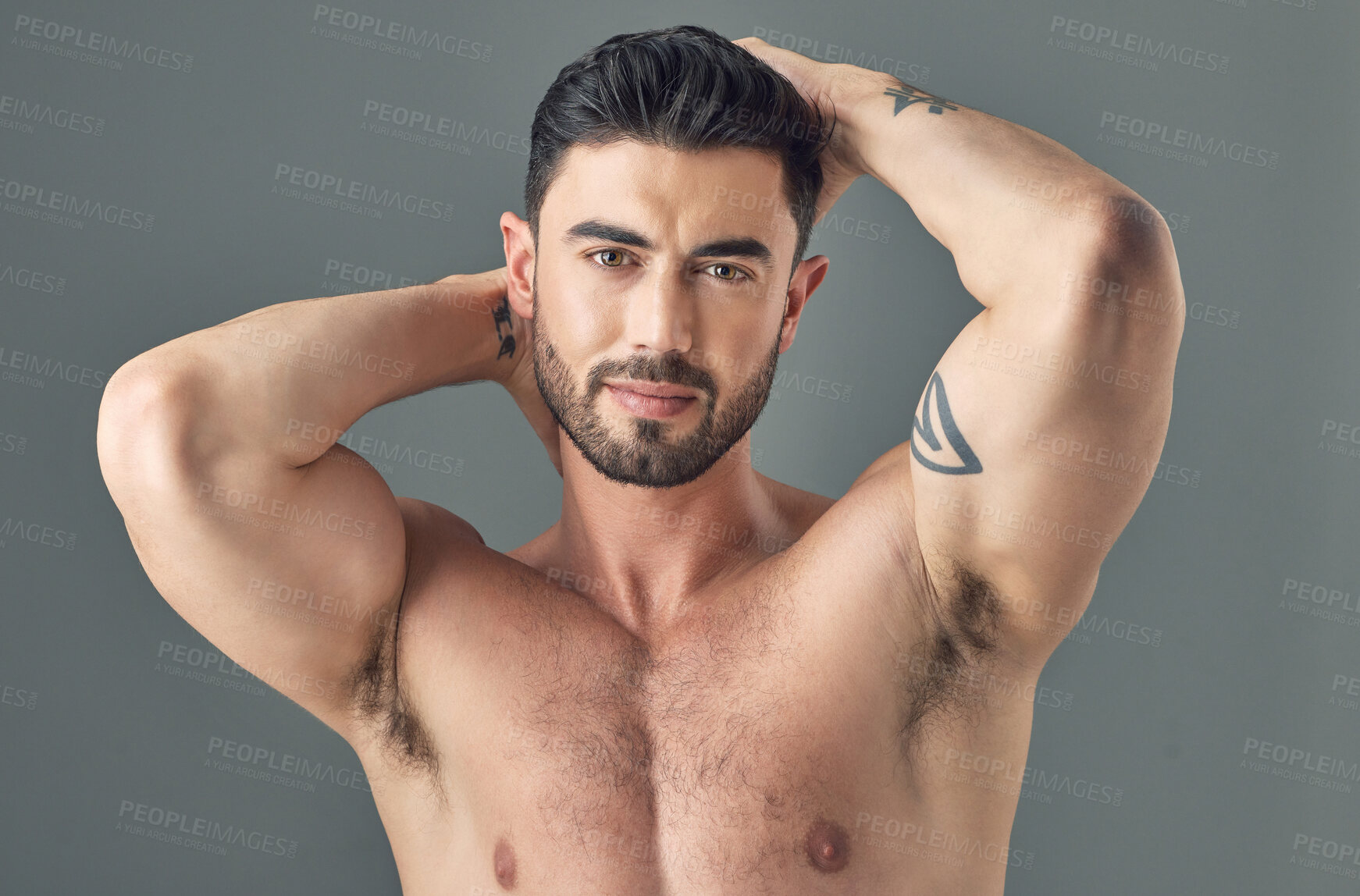 Buy stock photo Shot of a handsome young man posing against a grey background