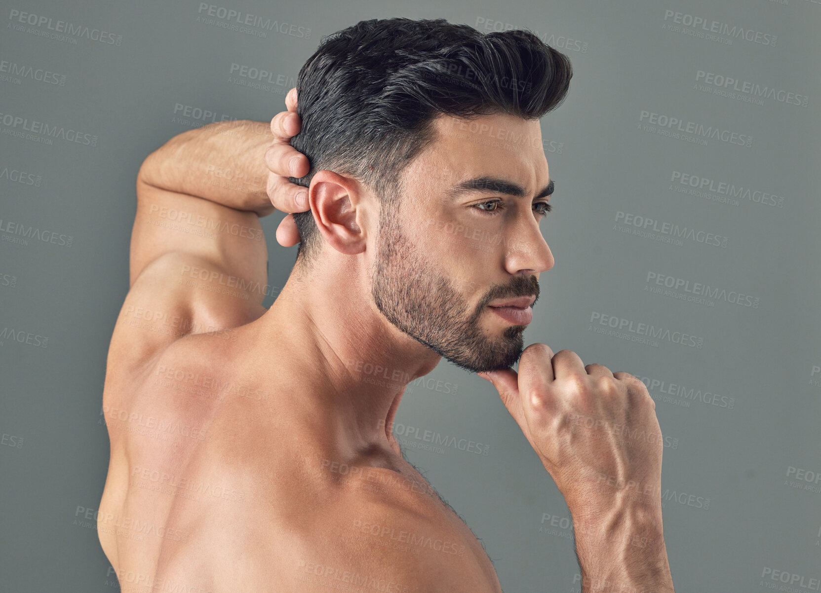 Buy stock photo Shot of a handsome young man posing against a grey background