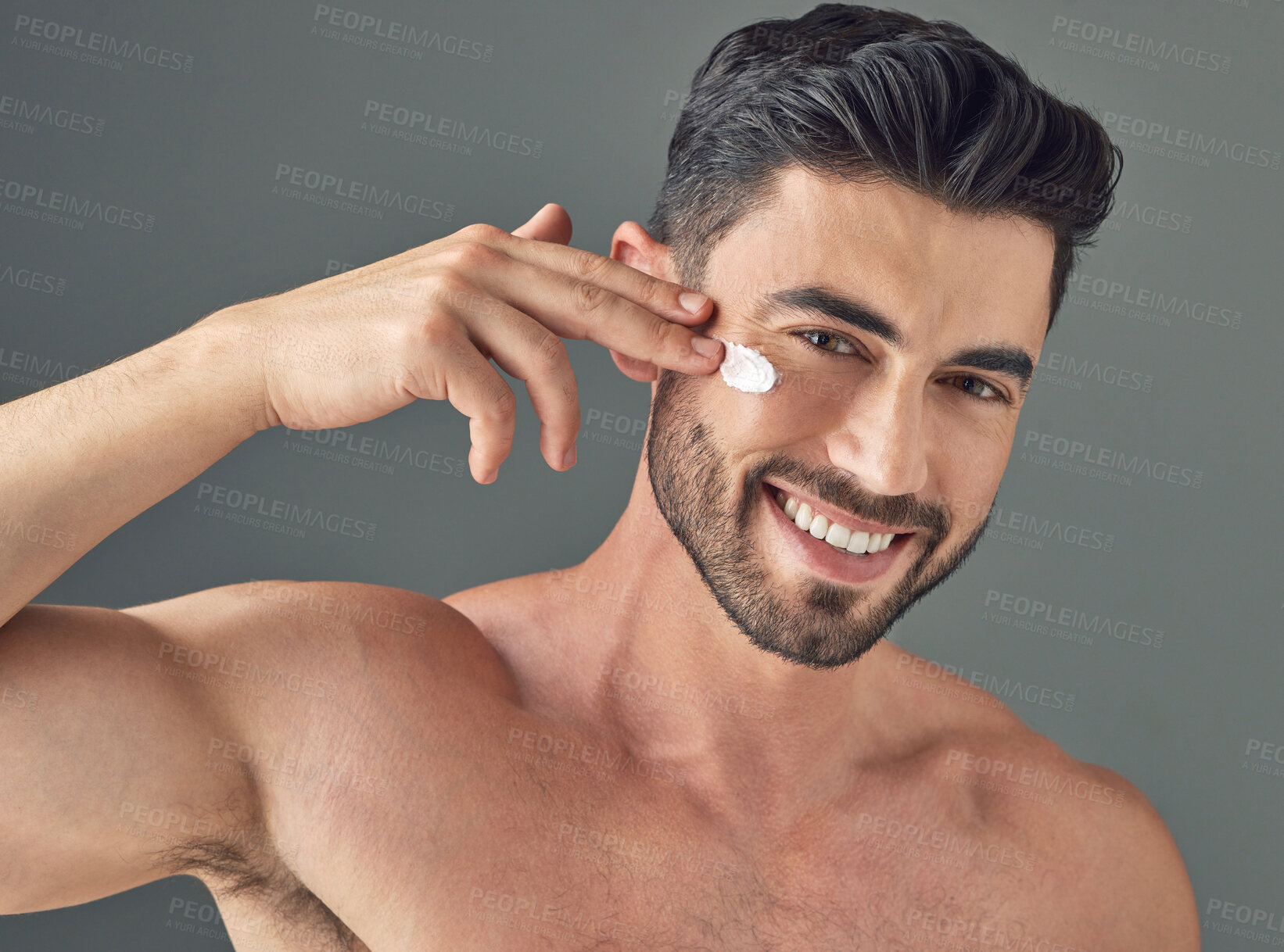 Buy stock photo Portrait, cream and man in studio with skincare, cosmetics and dermatology. Beauty, person and moisturiser treatment for lotion, maintenance and smile for hydration and glow on gray background