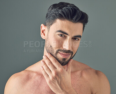 Buy stock photo Shot of a handsome young man posing against a grey background