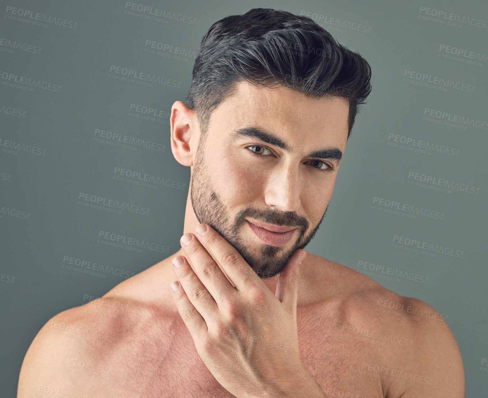 Buy stock photo Shot of a handsome young man posing against a grey background