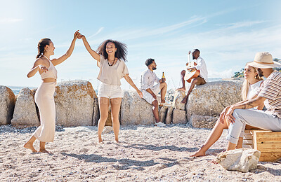 Buy stock photo Shot of two young women dancing while at the beach with their friends