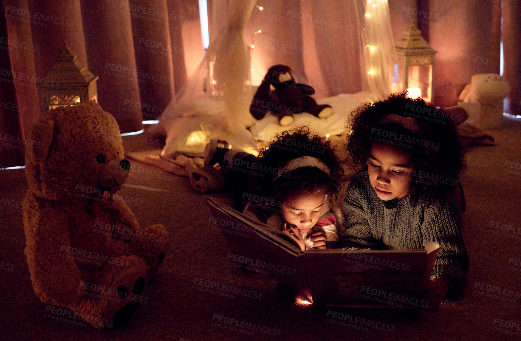 Buy stock photo Siblings, book and reading in night by house for bonding, fantasy or story together with fairy lights. Girls, novel and sparkle in bedroom in evening by home for education, development and bedtime 