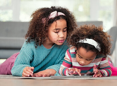 Buy stock photo Shot of two little girls playing on a digital tablet together at home