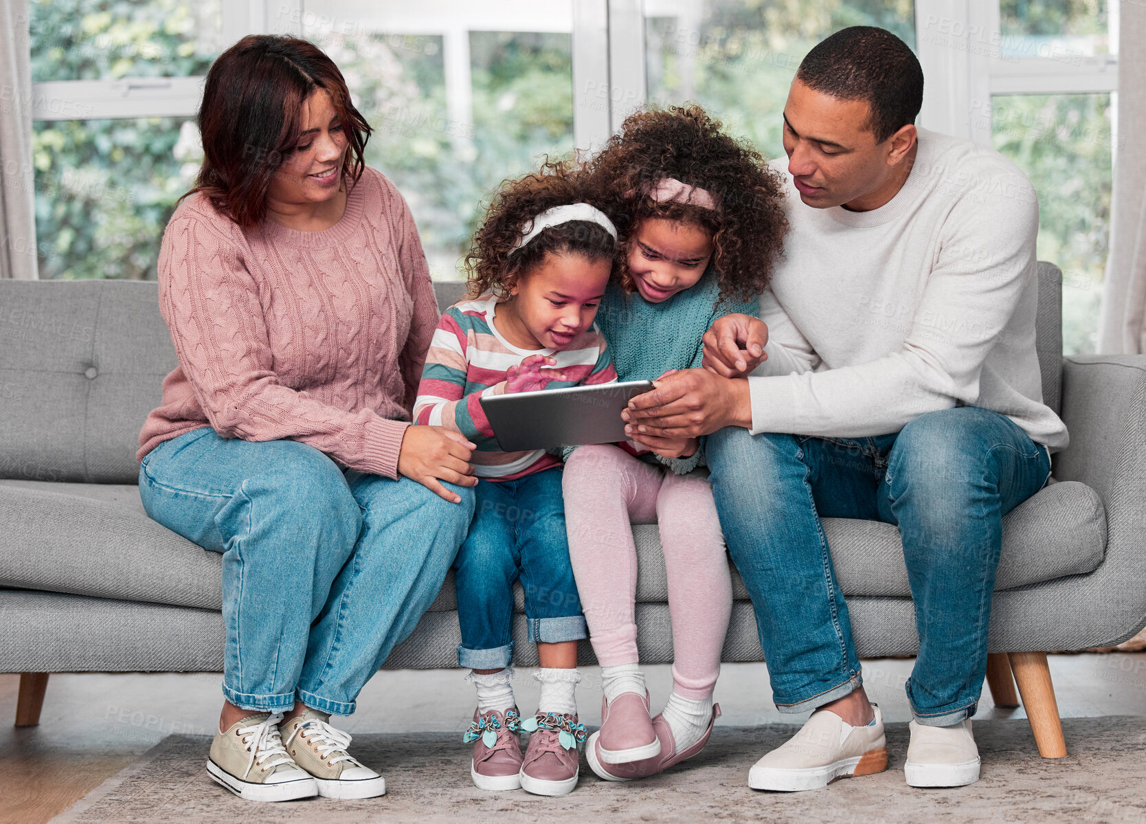 Buy stock photo Shot of a happy family using a digital tablet together at home