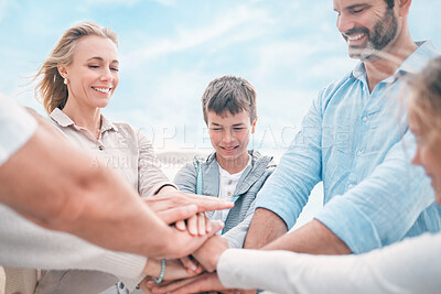 Buy stock photo Shot of a beautiful family stacking their hands while visiting the beach