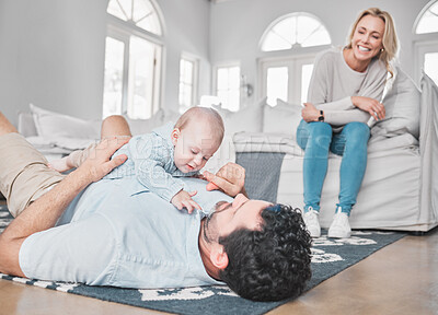 Buy stock photo Care, bonding and parents with baby in the living room of their house. Playful, happy and mother and father with love for a child while playing with affection on the floor of the lounge as a family