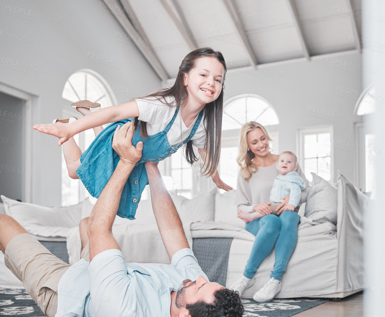 Buy stock photo Happy, airplane and family playing in the living room together while bonding in their modern home. Happy, smile and parents relaxing with their children with love, care and happiness in a house.