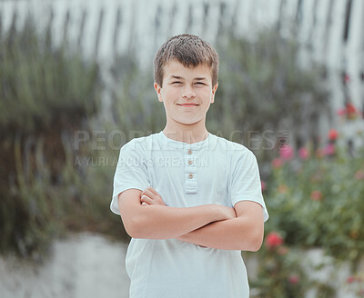 Buy stock photo Shot of a little boy standing with his arms crossed in the garden at home