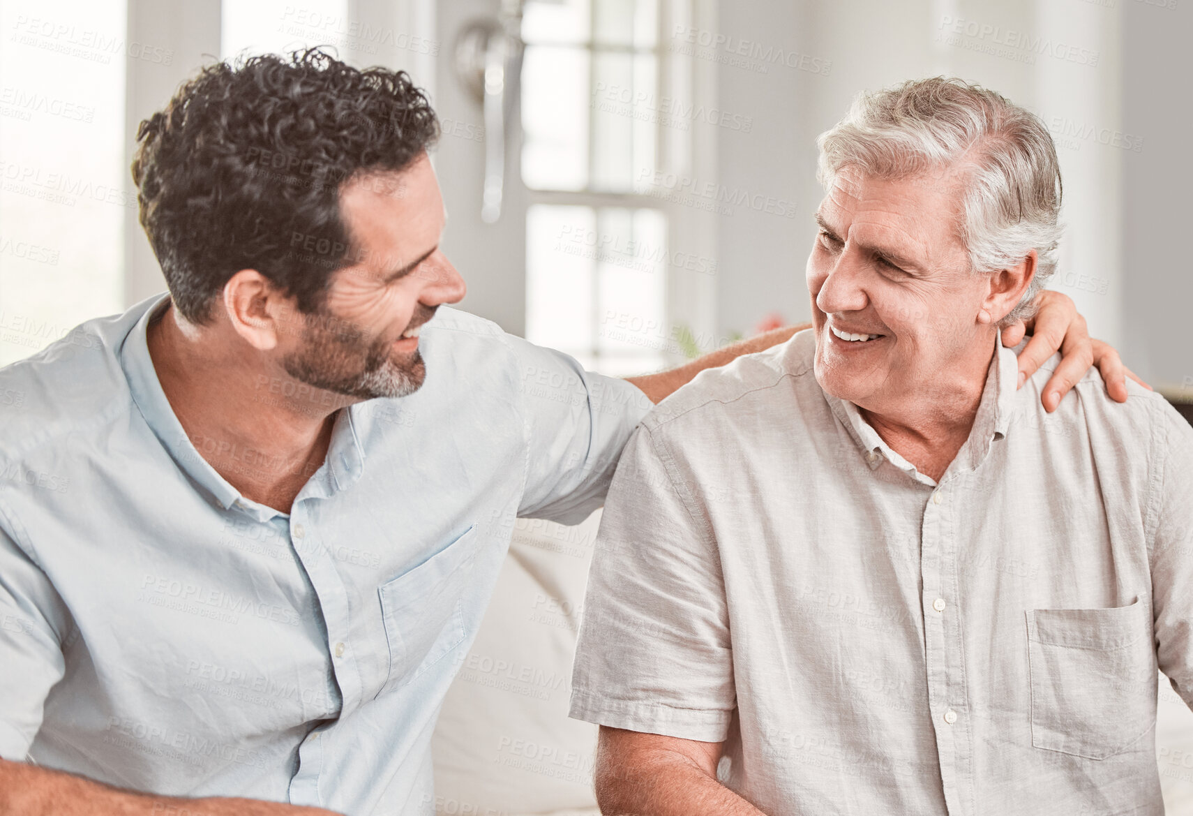 Buy stock photo Support, happy man and senior father in home for conversation, relax or family bonding for love. Smile, adult son and mature parent in lounge for comfort, connection and story of generations together