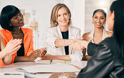 Buy stock photo Shot of two businesswomen shaking hands in a meeting at work