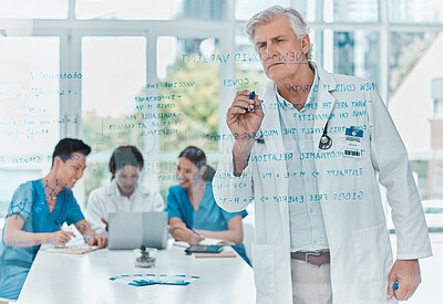 Buy stock photo Shot of a senior doctor brainstorming with notes on a glass wall in medical office