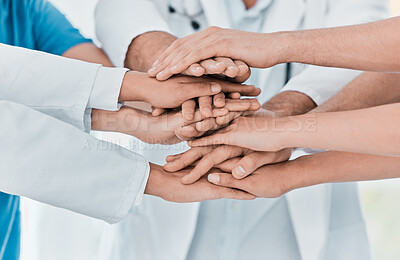Buy stock photo Closeup shot of a group of medical practitioners joining their hands together in a huddle in a hospital
