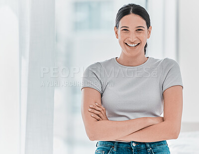 Buy stock photo Shot of an attractive young woman standing alone in the clinic with her arms folded